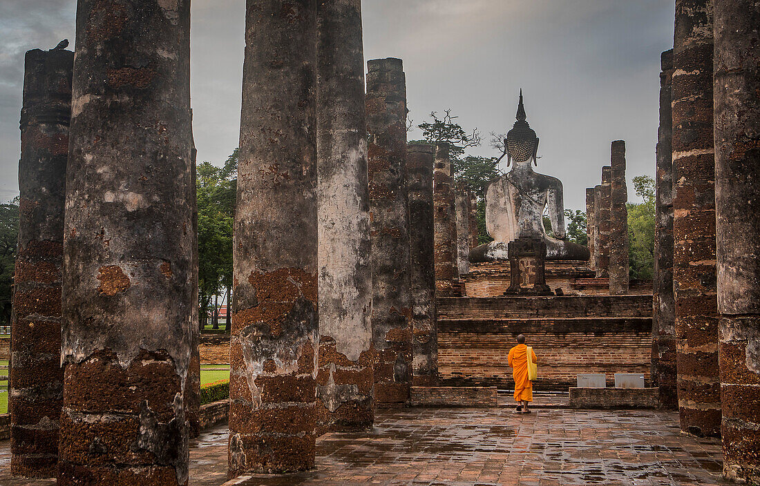 Monk praying, in Wat Mahathat, Sukhothai Historical Park, Sukhothai, Thailand