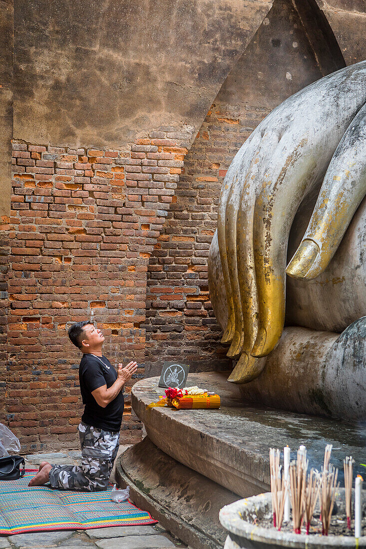 Man praying, Wat Si Chum, in Sukhothai historical park, Sukhothai, Thailand
