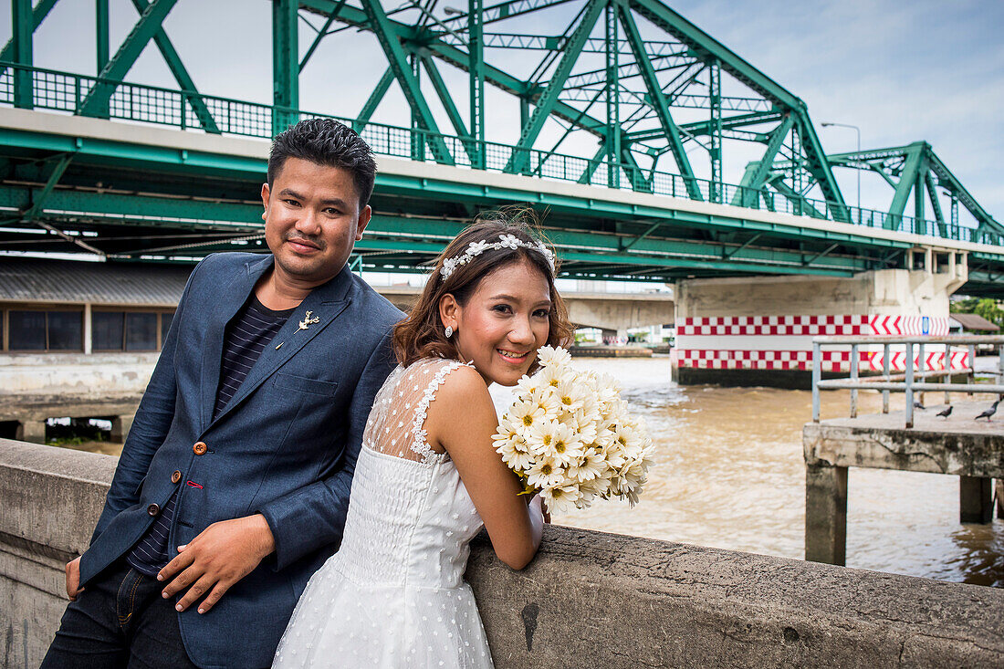 Just married, in background Memorial Bridge, Bangkok, Thailand