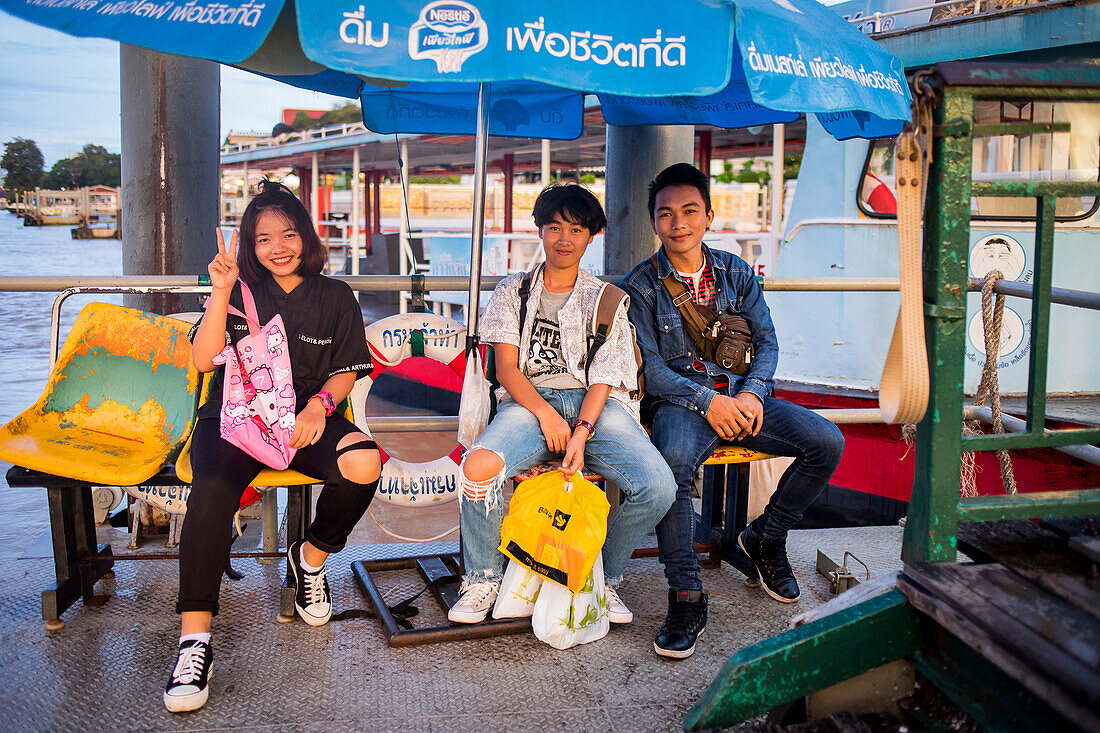 Freunde warten auf eine Expressfähre am Khun Mae Pueak Cross River Ferry Pier, Chao Phraya Fluss, Bangkok, Thailand