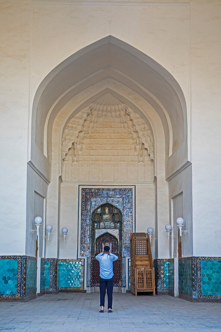 Man praying in front of mihrab, Kalon Mosque, Old Town, Bukhara, Uzbekistan