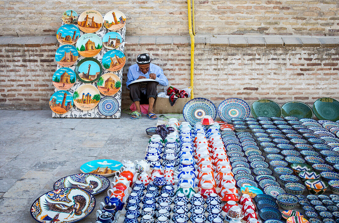 Kunsthandwerker, der traditionelle usbekische Töpferwaren verkauft, Buchara, Usbekistan