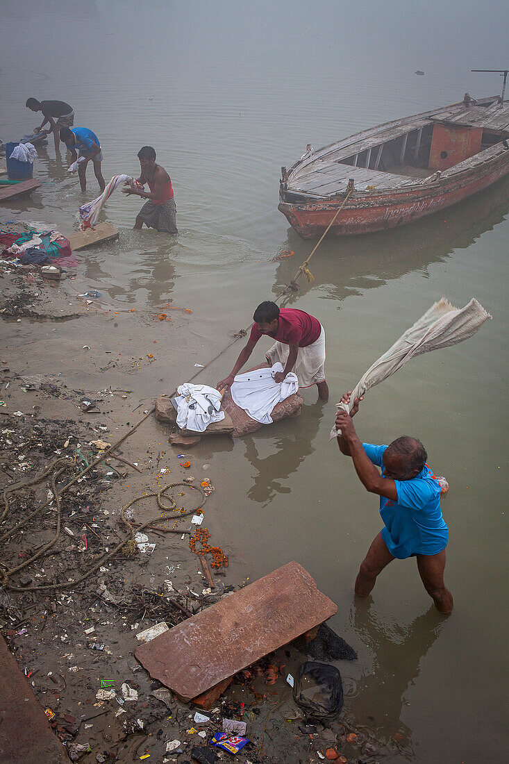 workers washing clothes, in Ganges river, Varanasi, Uttar Pradesh, India.