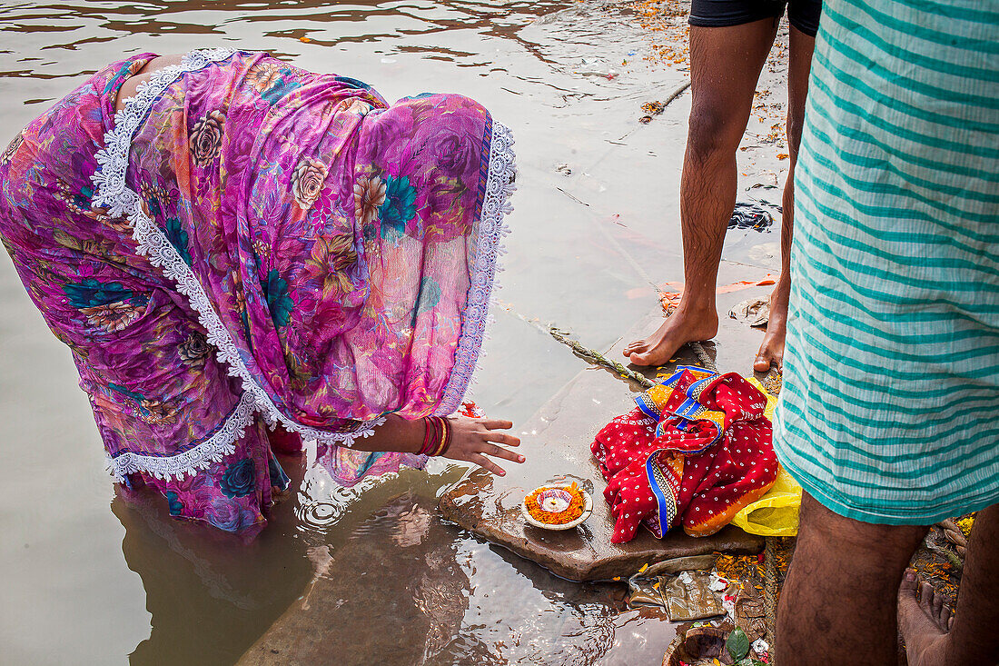 Frau macht Opfergabe, in den Ghats des Ganges, Varanasi, Uttar Pradesh, Indien.