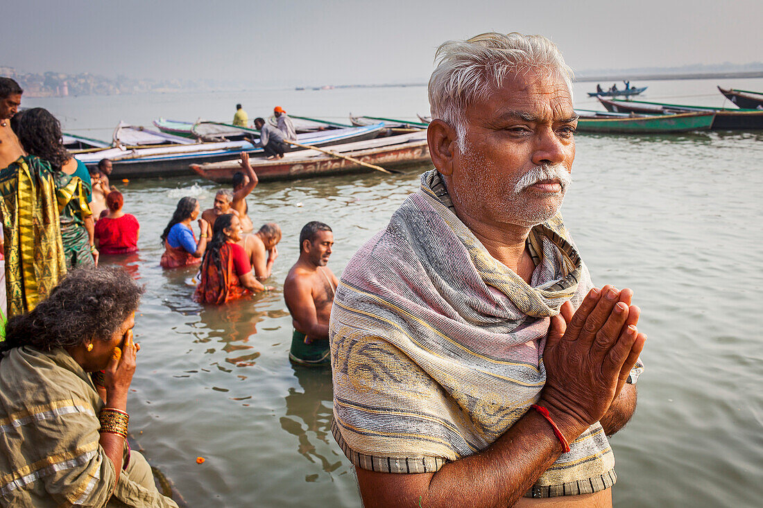 Pilgrims praying and bathing, in the ghats of Ganges river, Varanasi, Uttar Pradesh, India.