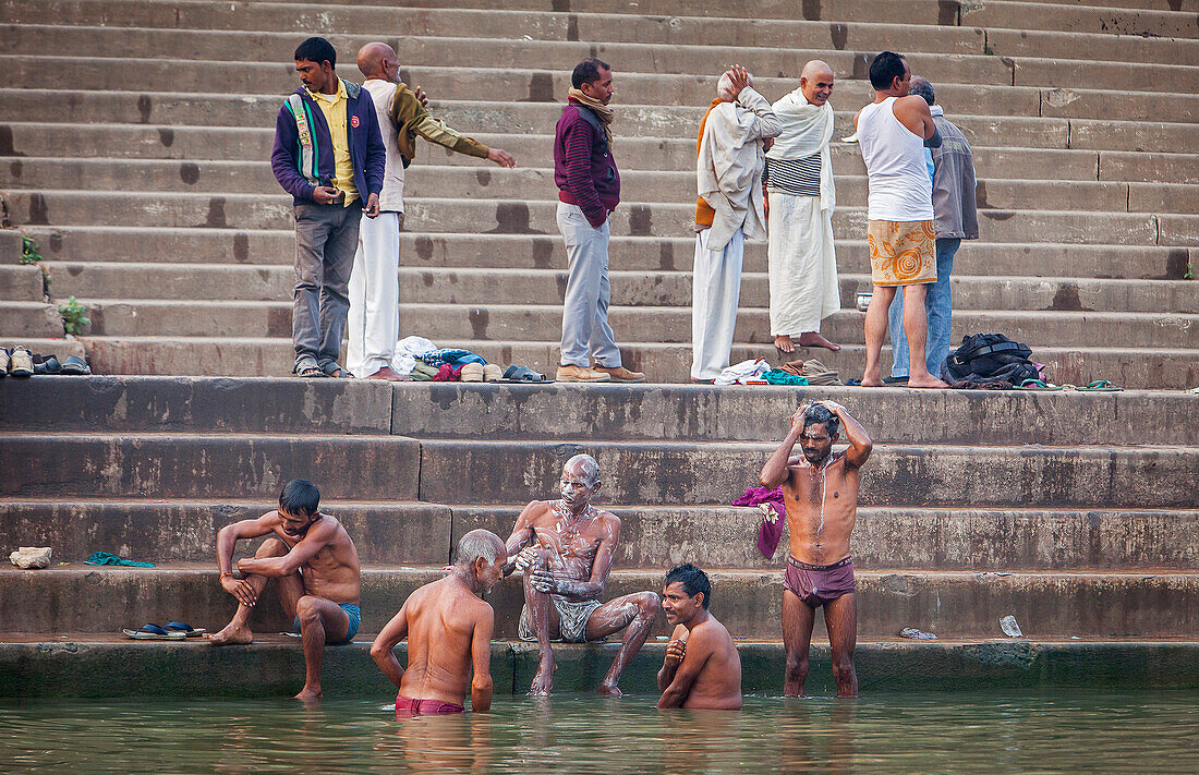 Pilger beim Beten und Baden an den Ghats des Ganges, Varanasi, Uttar Pradesh, Indien.