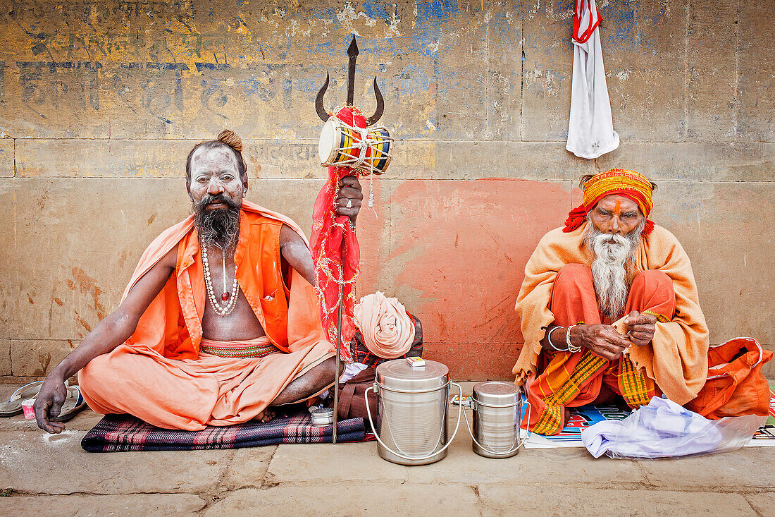Sadhus beten und betteln an den Ghats des Ganges, Varanasi, Uttar Pradesh, Indien.