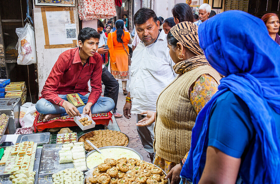 Mann verkauft Süßigkeiten. Süßwarengeschäft oder Konditorei, in Gotam Nagar Straße (Hauptstraße), Historisches Zentrum, Vrindavan, Mathura, Uttar Pradesh, Indien