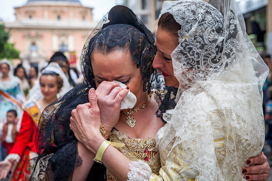 Nachdem sie die Jungfrau gesehen haben, weinen Frauen in Fallera-Kostümen während der Blumenopfer-Parade zu Ehren des "Virgen de los desamparados", Fallas-Festival, Plaza de la Virgen, Valencia