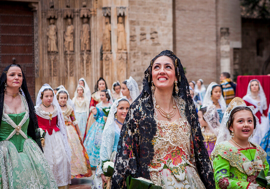 Frau blickt mit Rührung auf die Jungfrau während des Blumenkorsos, Menschen mit Blumengaben für die Virgen de los Desamparados, Fallas-Fest, Plaza de la Virgen, Valencia