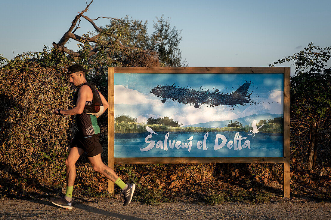 Plakat mit der Aufschrift "Retten wir das Delta" in der Nähe des Flughafens von Barcelona im Llobregat-Delta: Die Erweiterung des Flughafens droht mit der Zerstörung des Llobregat-Deltas und einem Anstieg der Kohlenstoffemissionen.