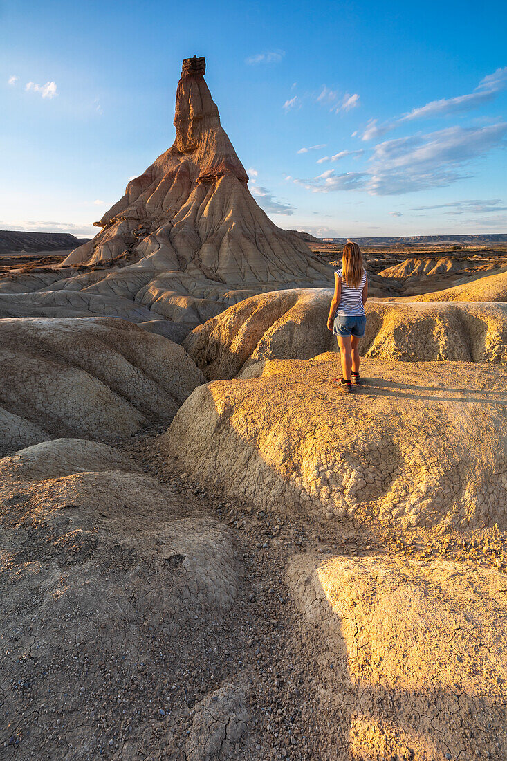 Woman observes Castil de Tierra at sunset, Bardenas Reales, Ebro Valley, Biosphere Reserve, Navarra, Spain, Western Europe