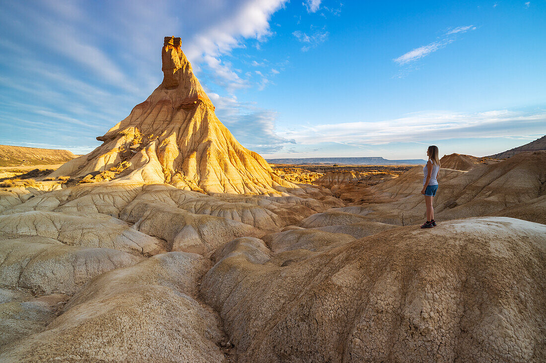 A woman observes Castil de Tierra at sunrise, Bardenas Reales, Ebro Valley, Biosphere Reserve, Navarra, Spain, Western Europe