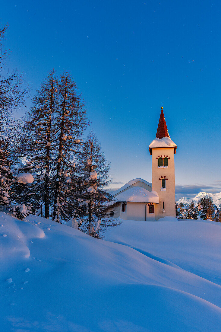 Blaue Stunde an der Chiesa Bianca, umgeben von Schnee, Maloja, Bergell, Kanton Graubünden, Engadin, Schweiz