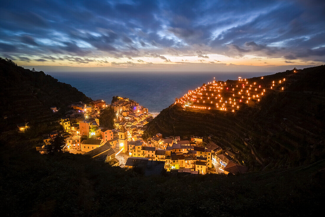 The lights of the sea village of Vernazza with the typical crib on the hill, Cinque Terre national park, province of La Spezia, Liguria, Italy.