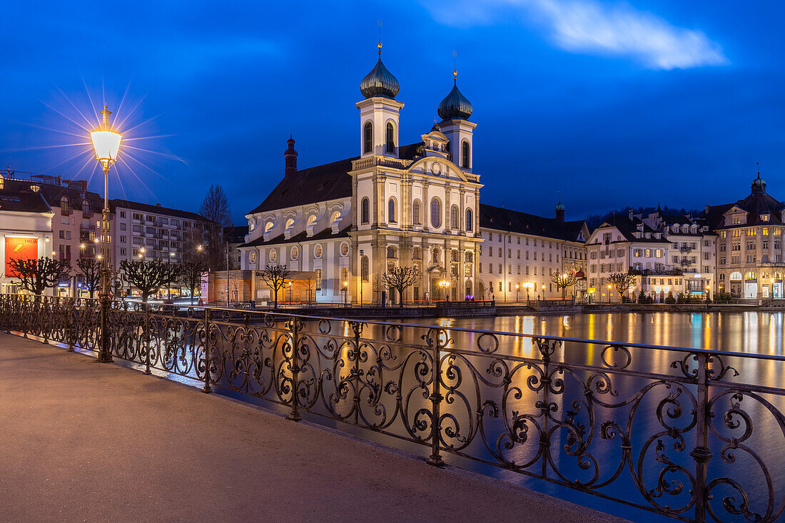 View of the Jesuit Church and the old town of Lucerne at blue hour reflected on the Reuss river. Lucerne, canton of Lucerne, Switzerland.