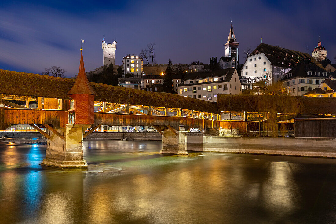 Blick auf den Holzsteg der Spreuerbrücke bei Nacht im Spiegel der Reuss. Luzern, Kanton Luzern, Schweiz.