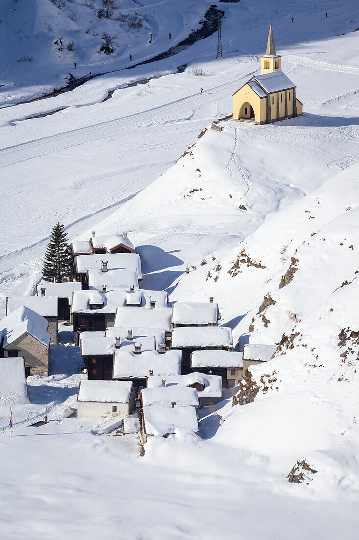 View of the church and town of Riale in winter from the road to the Maria Luisa refuge and the high Formazza Valley. Riale, Formazza, Valle Formazza, Verbano Cusio Ossola, Piedmont, Italy.