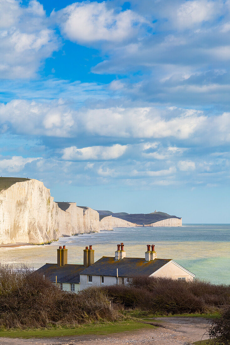 View of the Seven Sisters cliffs and the coastguard cottages, from Seaford Head across the River Cuckmere. Seaford, Sussex, England, United Kingdom.