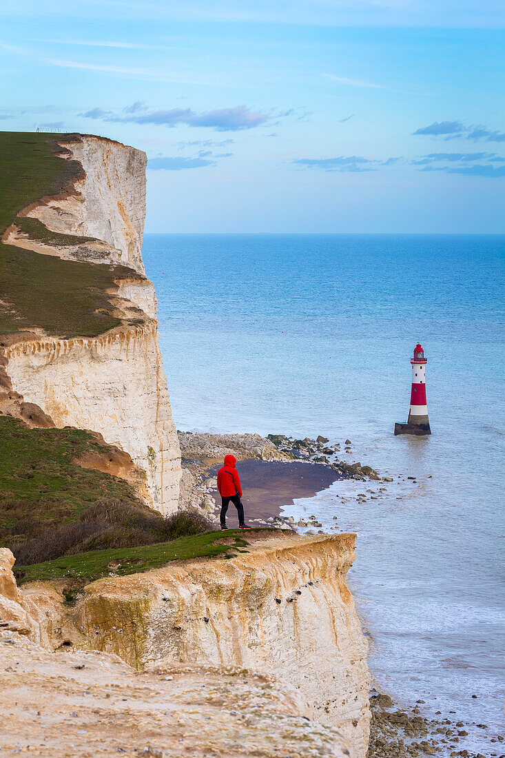 Eine Person blickt von der Kreidefelseninsel auf den Leuchtturm von Beachy Head. Eastbourne, Ost-Sussex, Südengland.