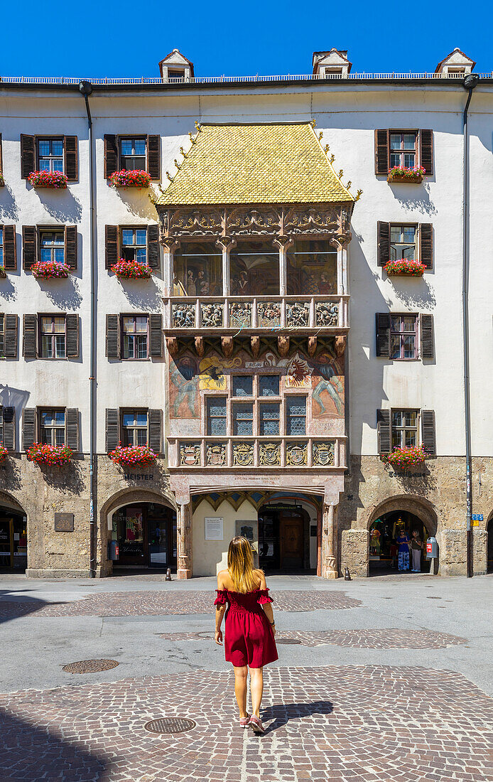 A woman observes Goldenes Dachl, Innsbruck, Innsbruck-land, Tyrol, Austria, Western Europe