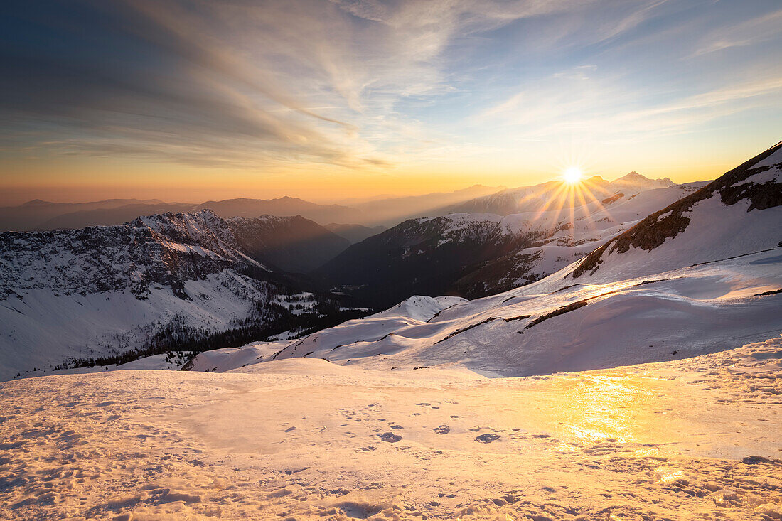 Blick auf das schneebedeckte Scalvetal bei Sonnenaufgang von den Ausläufern des Monte Ferrante. Colere, Val di Scalve, Bezirk Bergamo, Lombardei, Italien, Südeuropa.