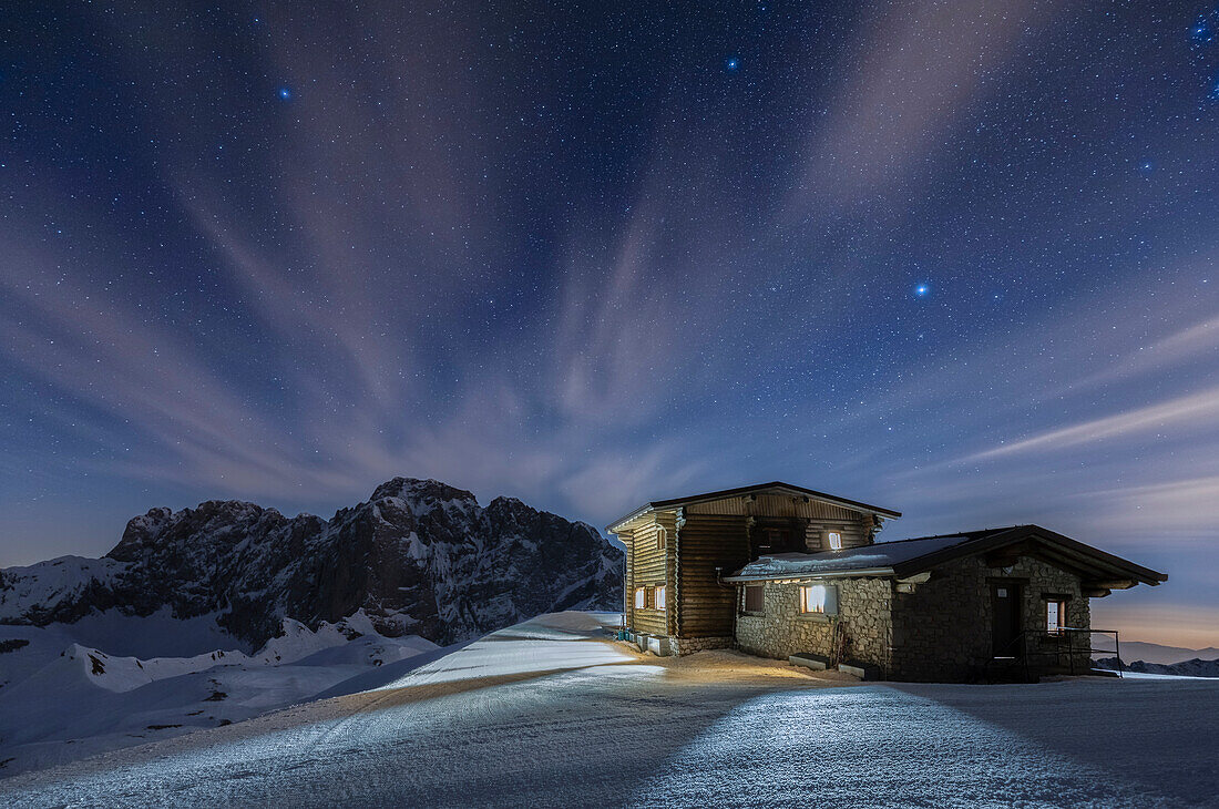 View of the snow-covered north face of the Presolana mountain in winter at night with the Aquila refuge. Colere, Val di Scalve, Bergamo district, Lombardy, Italy, Southern Europe.
