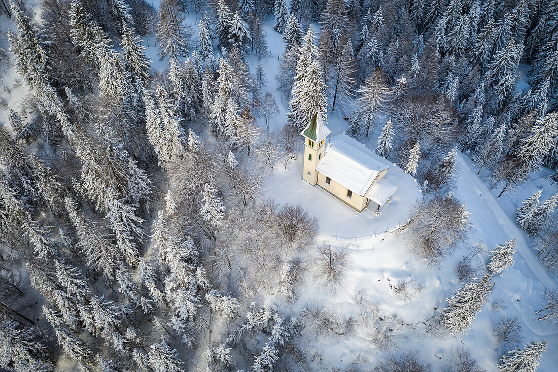 Luftaufnahme der Silvestri-Kirche nach einem winterlichen Sonnenaufgang. Presolana-Pass, Castione della Presolana, Seriana-Tal, Provinz Bergamo, Lombardei, Italien.