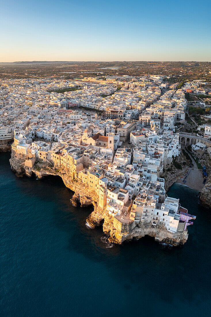 Aerial view of the overhanging houses of Polignano a Mare at sunrise. Bari district, Apulia, Italy, Europe.