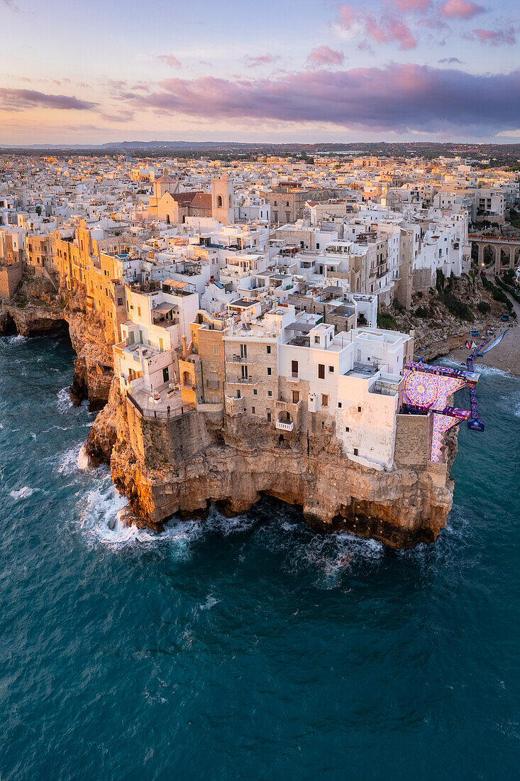 Aerial view of the overhanging houses of Polignano a Mare at sunrise. Bari district, Apulia, Italy, Europe.