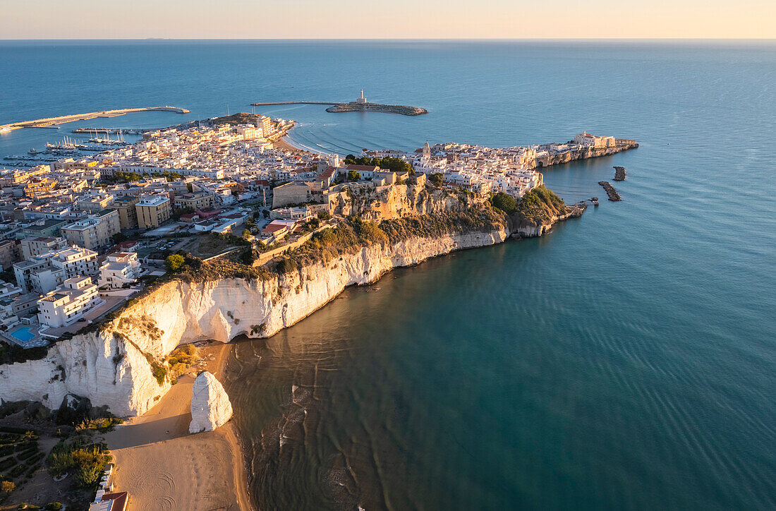 Aerial view of Pizzomunno beach and the white stack with Vieste peninsula in the background. Foggia province, Gargano National Park, Apulia, Italy.