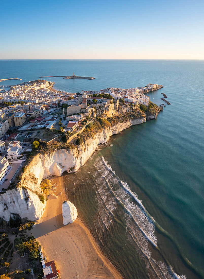 Aerial view of Pizzomunno beach and the white stack with Vieste peninsula in the background. Foggia province, Gargano National Park, Apulia, Italy.