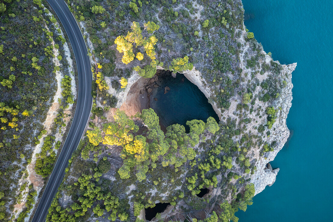 Aerial view of Grotta Sfondata cave on the coast near Vieste. Foggia province, Gargano National Park, Apulia, Italy.