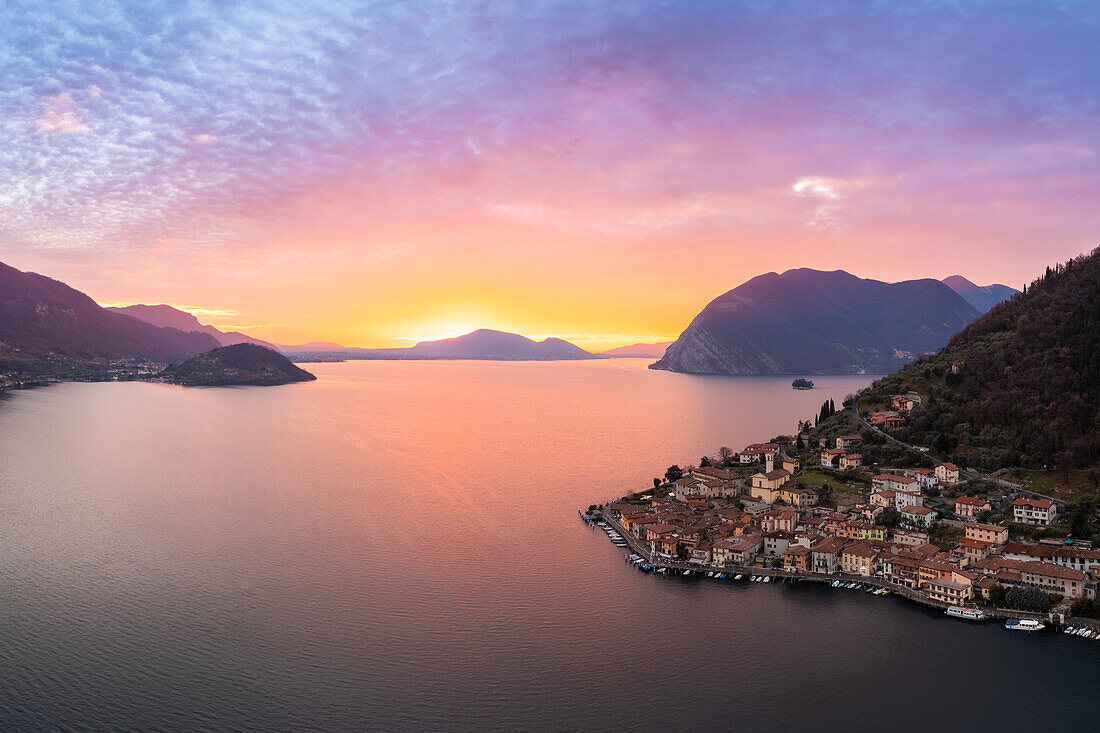 Luftaufnahme des Monte Isola und des Dorfes Peschiera Maraglio bei Sonnenuntergang am Iseosee. Peschiera Maraglio, Montisola, Provinz Brescia, Region Lombardei, Italien, Europa.