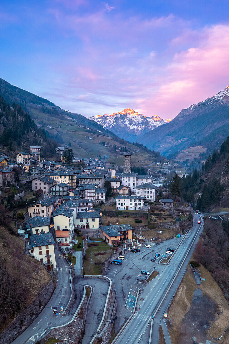 Das Dorf Gromo mit dem bei Sonnenuntergang beleuchteten Pizzo Redorta im Hintergrund. Gromo, Val Seriana, Provinz Bergamo, Lombardei, Italien, Europa.