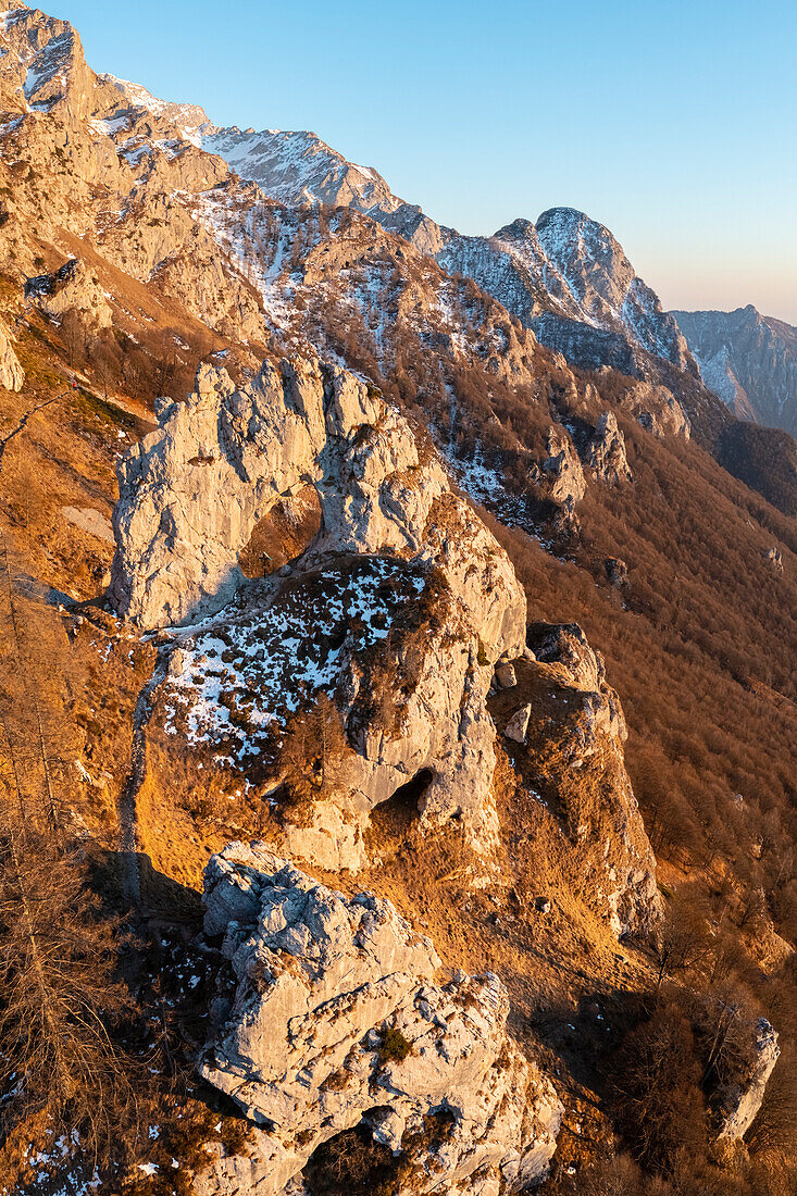 Aerial view of the natural rock arch called Porta di Prada with the Grigna Settentrionale mountain behind at sunset. Grigna Settentrionale(Grignone), Mandello del Lario, Lombardy, Italy.