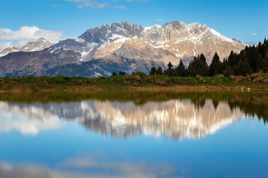 View of the Presolana mountain reflected on a spring pond on Monte Pora. Songavazzo, Val Seriana, Bergamo district, Lombardy, Italy, Southern Europe.