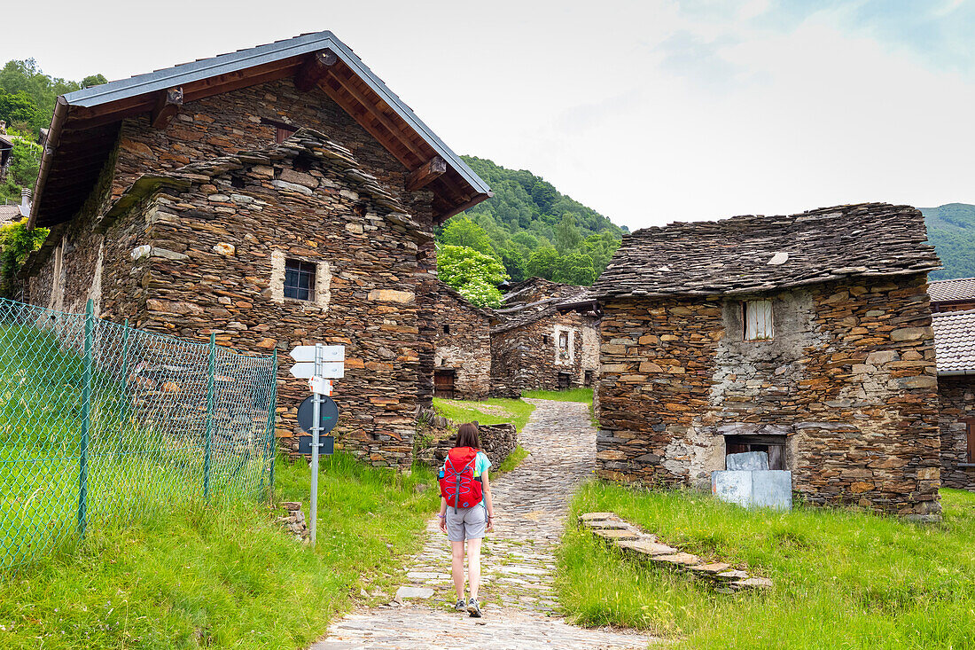Blick auf einen Wanderer im kleinen Dorf Sarona, Curiglia con Monteviasco, Veddasca-Tal, Bezirk Varese, Lombardei, Italien.