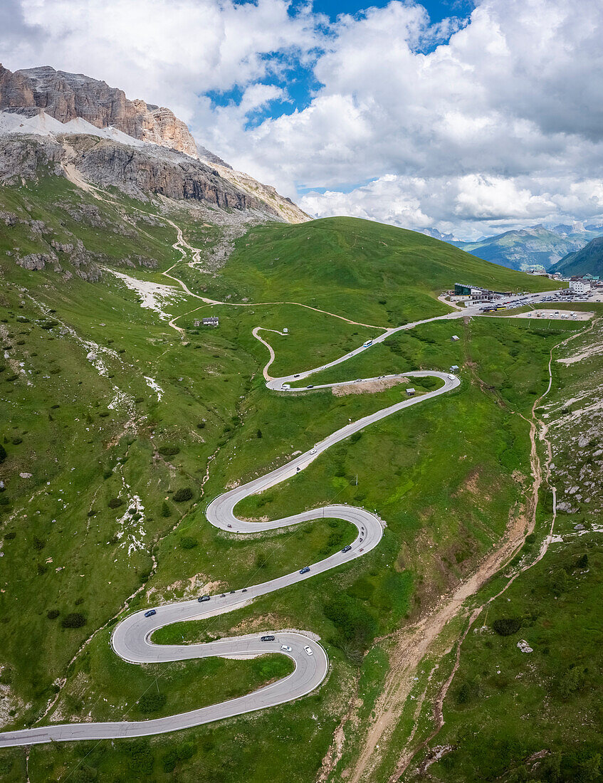 Blick aus der Vogelperspektive auf die kurvenreiche Straße des Pordoijochs an einem Sommertag. Fassa-Tal, Dolomiten, Canazei, Provinz Trient, Bezirk Trentino-Südtirol, Italien, Europa.