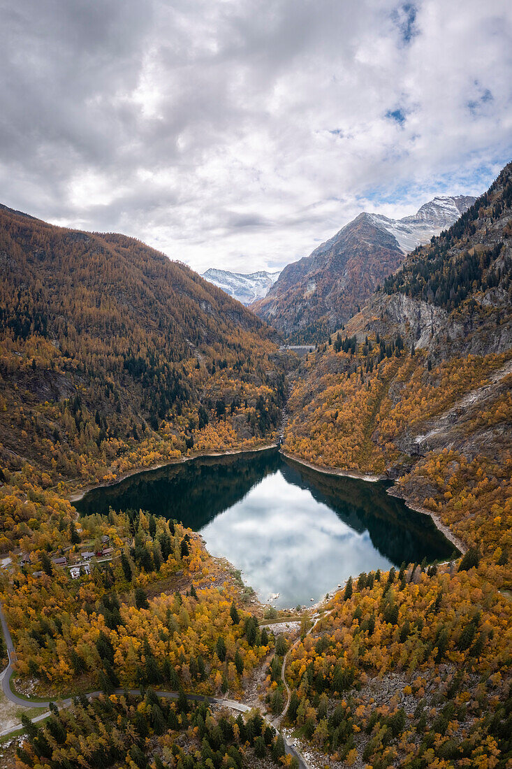 Blick auf den Lago d'Antrona und den Damm des Lago Campliccioli im Herbst. Antrona, Antrona-Tal, Piemont, Verbano Cusio Ossola, Italien.