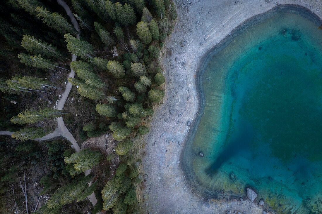 Aerial view of the Karersee lake in autumn at sunrise. Carezza, Dolomites, South Tyrol, Trentino Alto Adige, Italy.