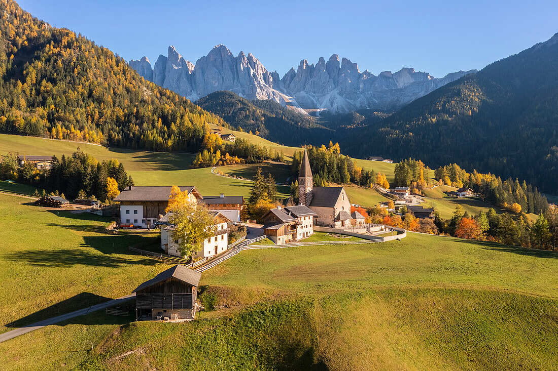 Luftaufnahme der Kirche von Santa Maddalena mit der Geislergruppe im Hintergrund. Santa Magdalena Val di Funes, Fünser Tal, Bozen, Südtirol, Trentino Südtirol, Italien.