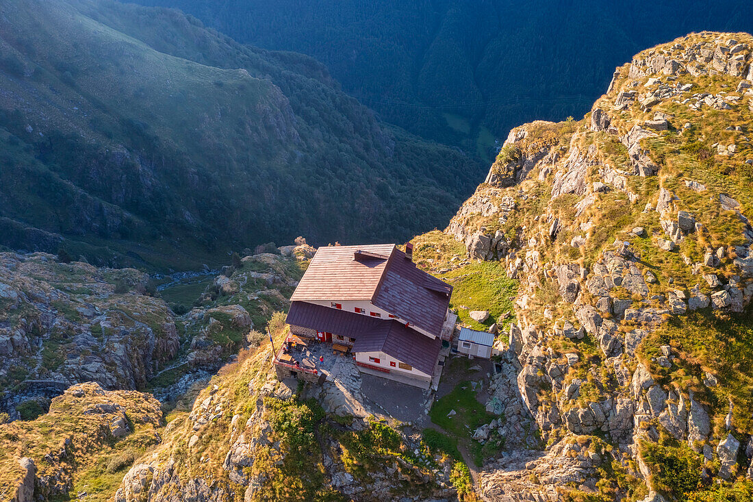 Aerial view of Rifugio Merelli al Coca on a cliff overlooking Valbondione town. Valbondione, Seriana Valley, Lombardy, Bergamo province, Italy.