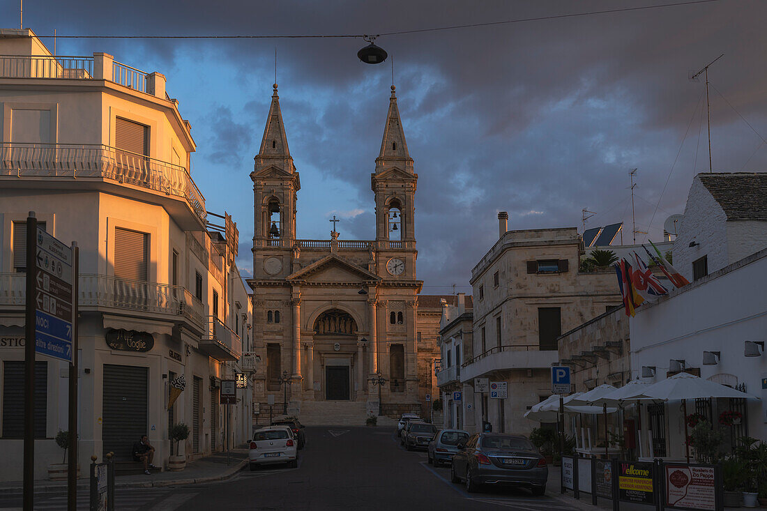 street view of Alberobello and the Basilica Saints Medici Cosma and Damiano. Alberobello, Bari province, Apulia, Italy, Europe