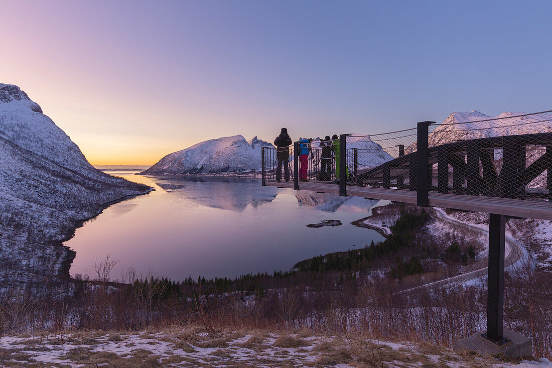 Europa, Norwegen, Insel Senja: Fotografen fotografieren bei Sonnenuntergang, der sich im Fjord auf der Bergsbotn-Übersichtsplattform spiegelt