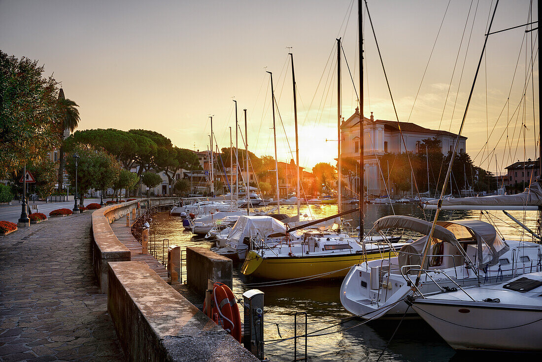 Toscolano Maderno gulf, with Church of St. Andrea and boats in sunrise, Lake of Garda, Toscolano Maderno, Brescia province, Lombardy, Italy, Europe, south Europe.