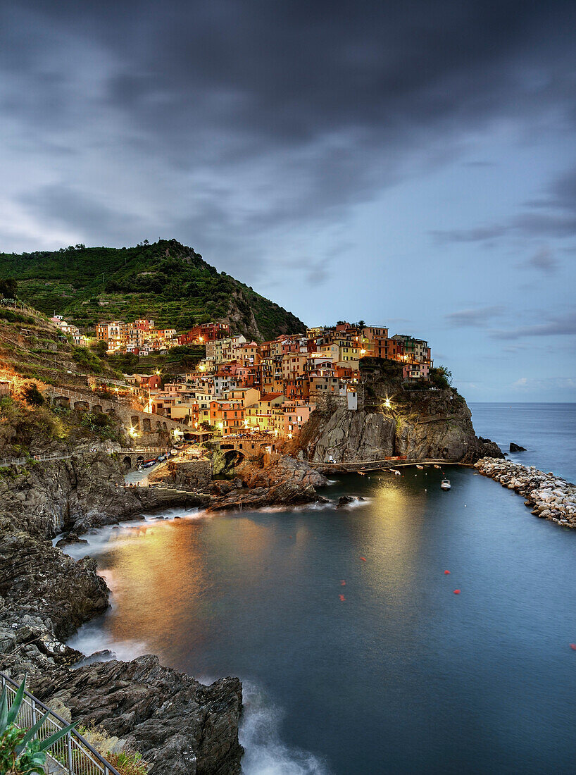 Manarola mit Blick auf das typische Haus, Hafen und felsigen Strand, in der Nacht während der blauen Stunde Manarola, La Spezia, Cinque Terre, Italien, Europa, Südeuropa