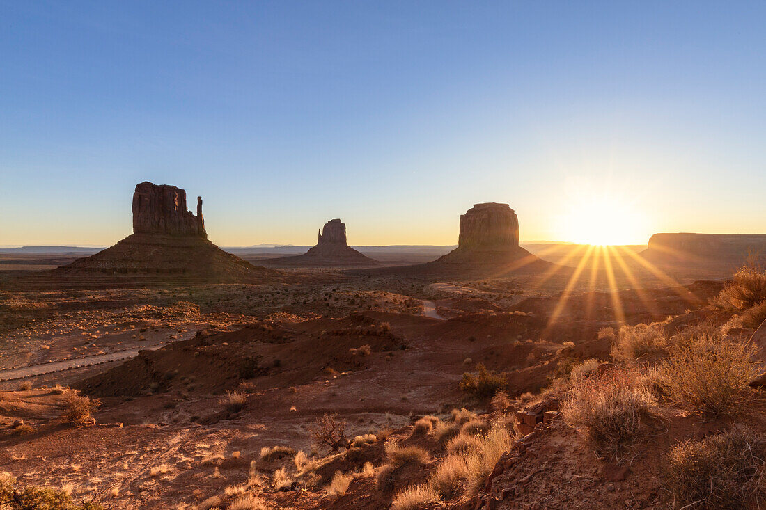 USA, Arizona: sun rising behind the iconic Monument Valley