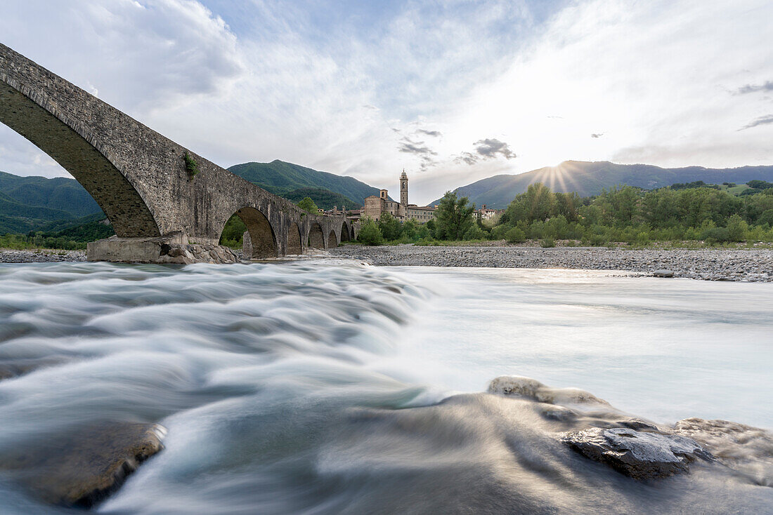 Europe, Italy, Emilia Romagna: Bobbio, the medieval town seen from the shores of Trebbia river under the Ponte Gobbo