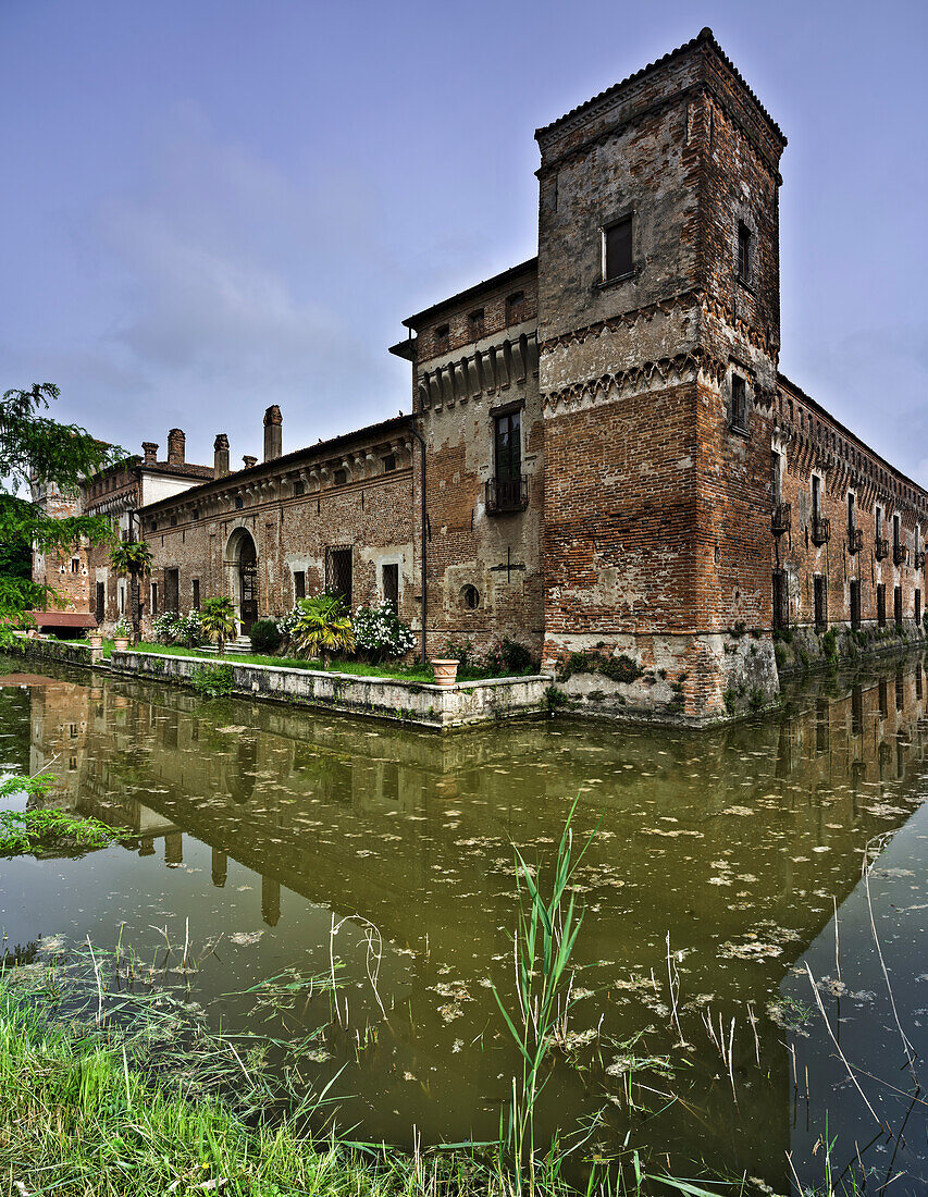 Detail des Wassergrabens des Schlosses Padernello mit Spiegelungen im Vordergrund und Bäumen mit Vegetation , Padernello, Brescia, Lombardei, Italien